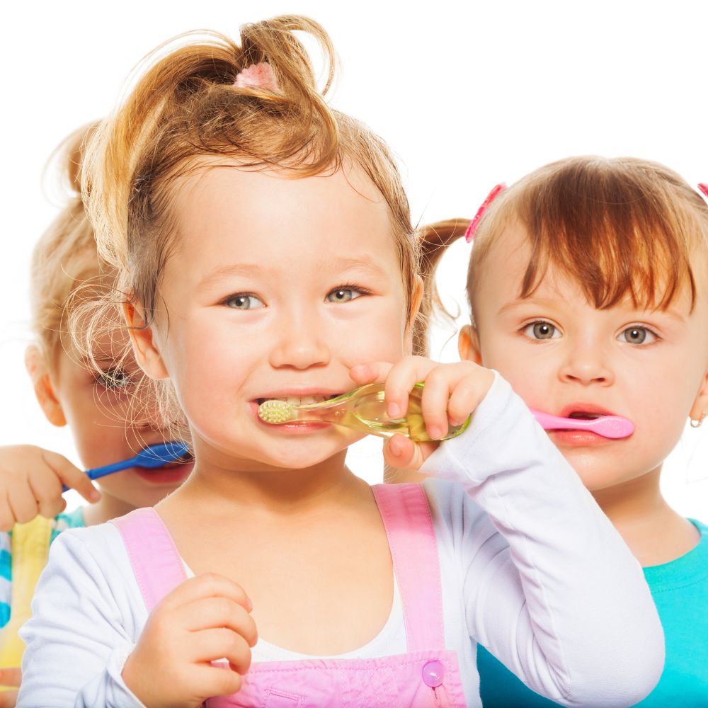 Young children brushing their teeth.
